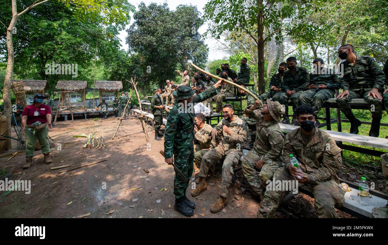A Royal Thai Army jungle survival instructor helps a soldier from 29th