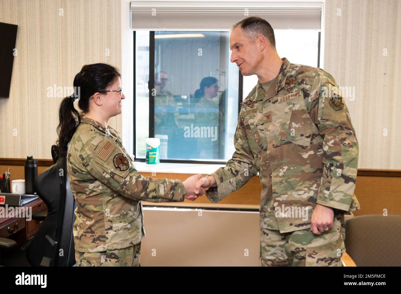 Col. Matt Husemann, left, 436th Airlift Wing commander, presents Senior Airman Netanya Aucamp, 436th Maintenance Squadron unit training monitor, with a certificate and coin as the week’s Top Performer at Dover Air Force Base, Delaware, March 14, 2022. Aucamp was also presented a coin by Chief Master Sgt. Timothy Bayes, 436th AW command chief, for outstanding performance. Stock Photo