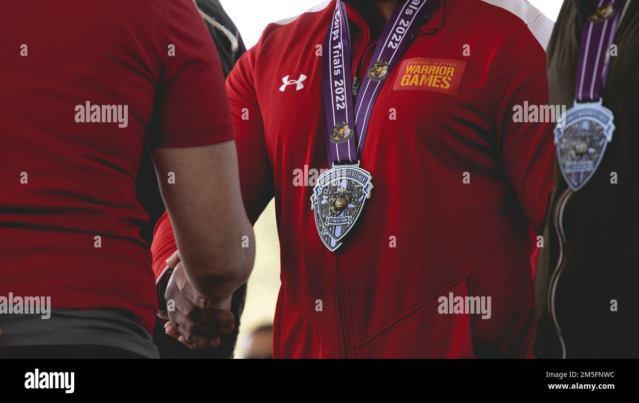 Award recipients receive medals for competing in the 2022 Wounded Warrior Battalion Marine Corps Trials during the closing ceremony on Marine Corps Base Camp Lejeune, North Carolina, March 14, 2022. The Marine Corps Trials is an annual adaptive sports competition that promotes a competitive warrior spirit, builds camaraderie and provides a venue to select participants for the 2022 DoD Warrior Games. Stock Photo