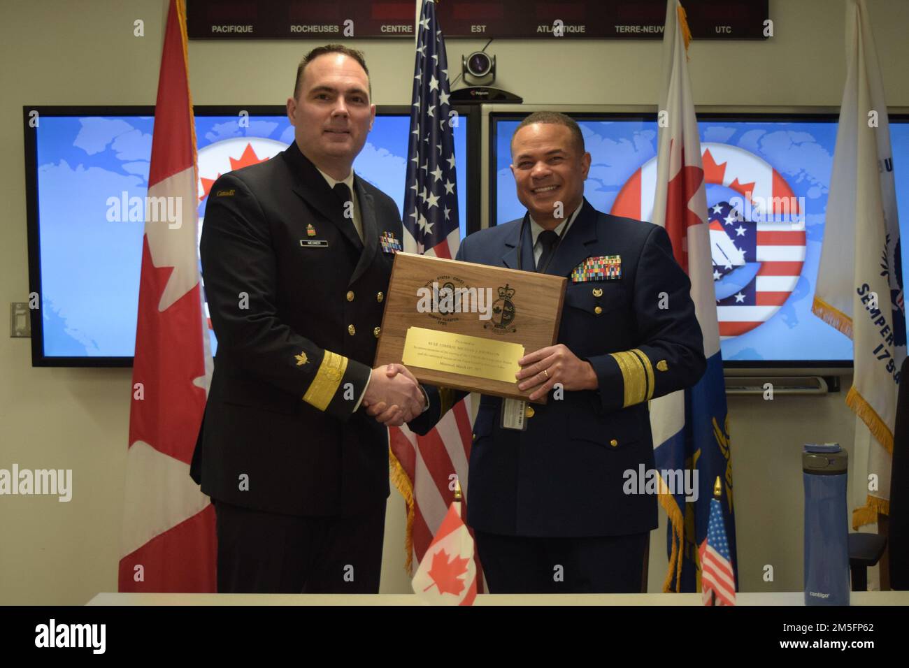 Marc-André Meunier, Central Region Assistant Commissioner Canadian Coast Guard, presents a gift to Rear Arm. Michael Johnston, Commander of the United States Coast Guard Ninth District, in Montreal, March 14, 2022. The United States and Canadian Coast Guards work closely together on a wide range of coast guard services across the Great Lakes, including environmental response, search and rescue, icebreaking, marine traffic management, and aids to navigation. (Canadian Coast Guard photo by Jennifer Moore) Stock Photo