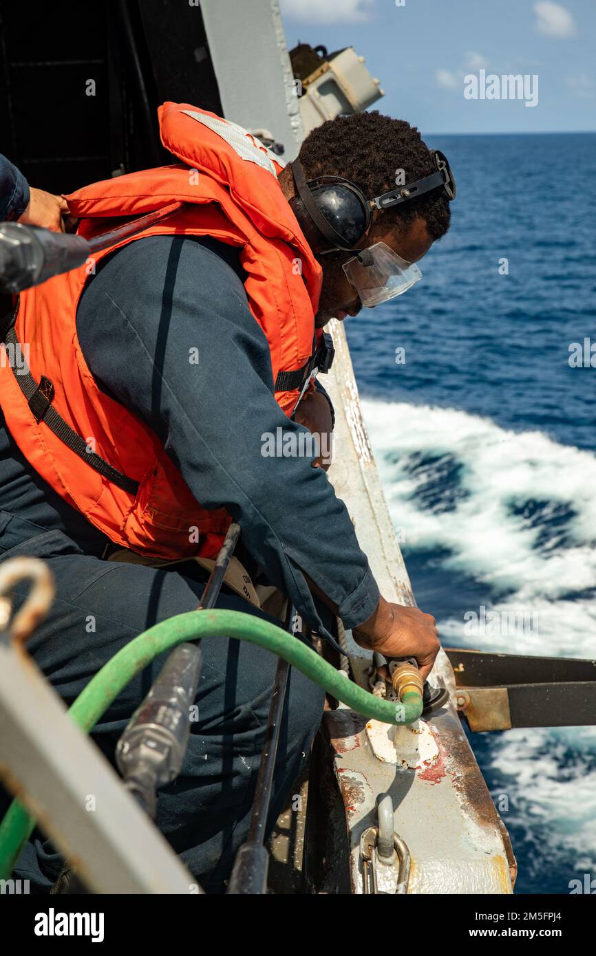 SOUTH CHINA SEA (March 14, 2022) Boatswain’s Mate Seaman Class Justin Stafford, from Richmond, Va., uses a grinder while conducting maintenance aboard the Arleigh Burke-class guided-missile destroyer USS Ralph Johnson (DDG 114). Ralph Johnson is assigned to Task Force 71/Destroyer Squadron (DESRON) 15, the Navy’s largest forward-deployed DESRON and the U.S. 7th fleet’s principal surface force. Stock Photo