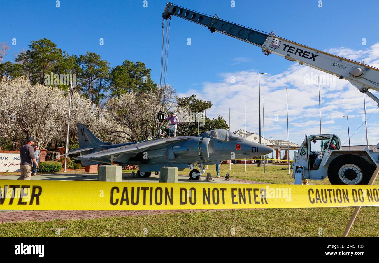 Fleet Readiness Center East employees fasten an AV-8B Harrier to a crane at Marine Corps Air Station (MCAS) Cherry Point, North Carolina, March 15, 2022. The aircraft was refurbished before returning to its static position in front of the MCAS Cherry Point Main Gate. Stock Photo