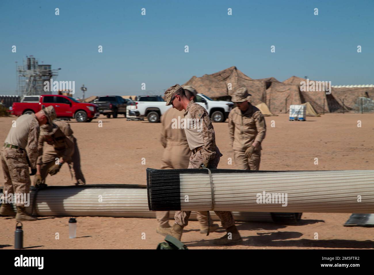 U.S. Marines attached to Marine Aviation Weapons and Tactics Squadron One (MAWTS-1), set up Mobi-Mats for an expeditionary airfield system practical application, during Weapons and Tactics Instructor (WTI) course 2-22, at Auxiliary Airfield II, in Yuma, Arizona, March 15, 2022. WTI is a seven-week training event hosted by MAWTS-1, providing standardized advanced tactical training and certification of unit instructor qualifications to support Marine aviation training and readiness, and assist in developing and employing aviation weapons and tactics. Stock Photo
