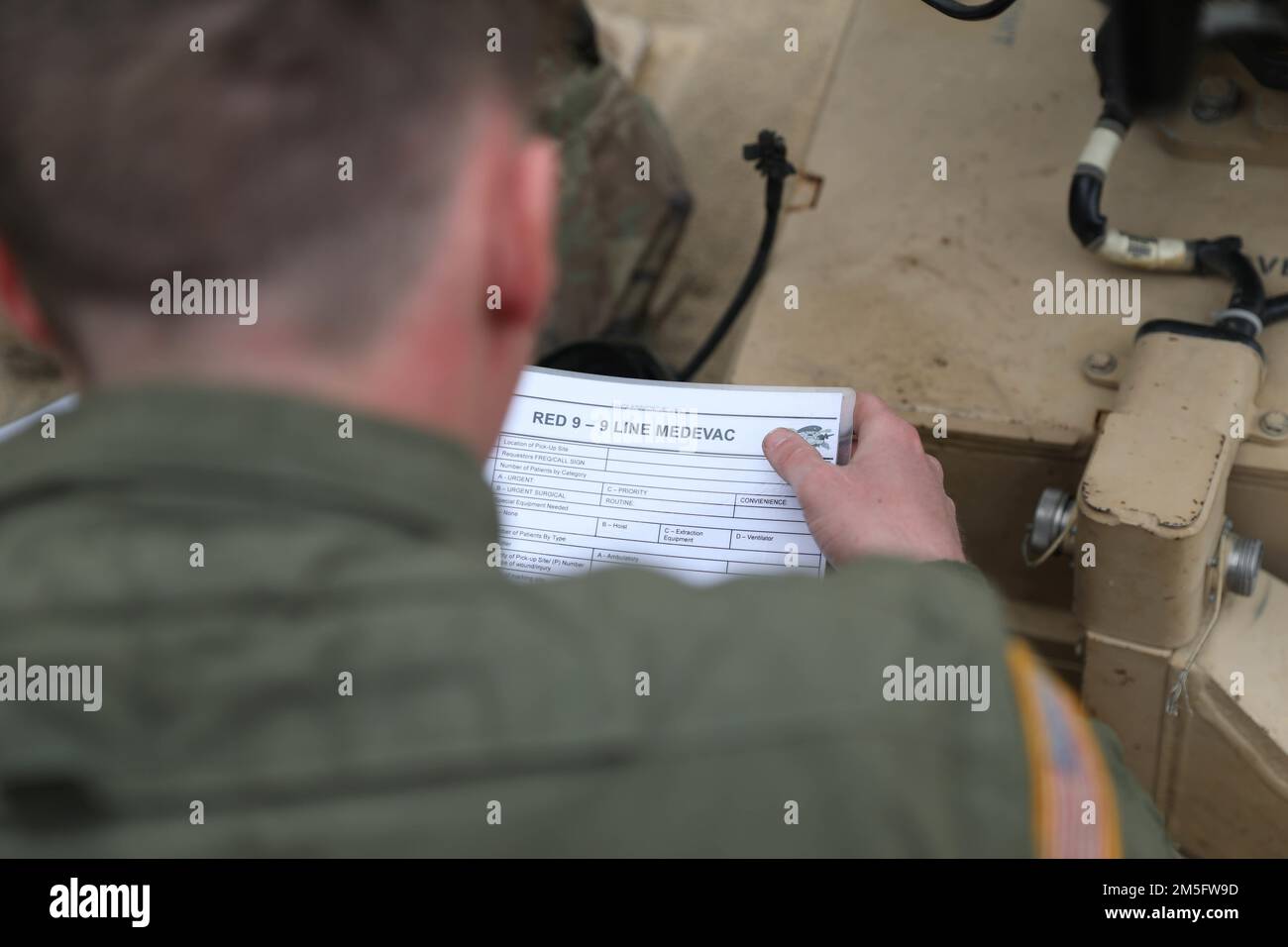 Spc. Austin Zink assigned to 2nd Battalion, 34th Armored Regiment, 1st Armored Brigade Combat Team, 1st Infantry Division, reviews the steps of a 9-line medical evacuation request as part of the land navigation training at Drawsko Pomorskie, Poland, March 15, 2022. Stock Photo