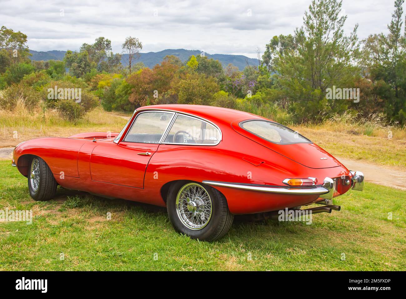 A red 1962 Jaguar E Type Coupe in an Australian rural setting. Stock Photo