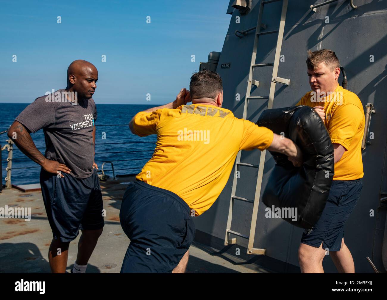 SOUTH CHINA SEA (March 15, 2022) Sailors participate in non-lethal weapons training aboard the Arleigh Burke-class guided-missile destroyer USS Ralph Johnson (DDG 114). Ralph Johnson is assigned to Task Force 71/Destroyer Squadron (DESRON) 15, the Navy’s largest forward-deployed DESRON and the U.S. 7th fleet’s principal surface force. Stock Photo