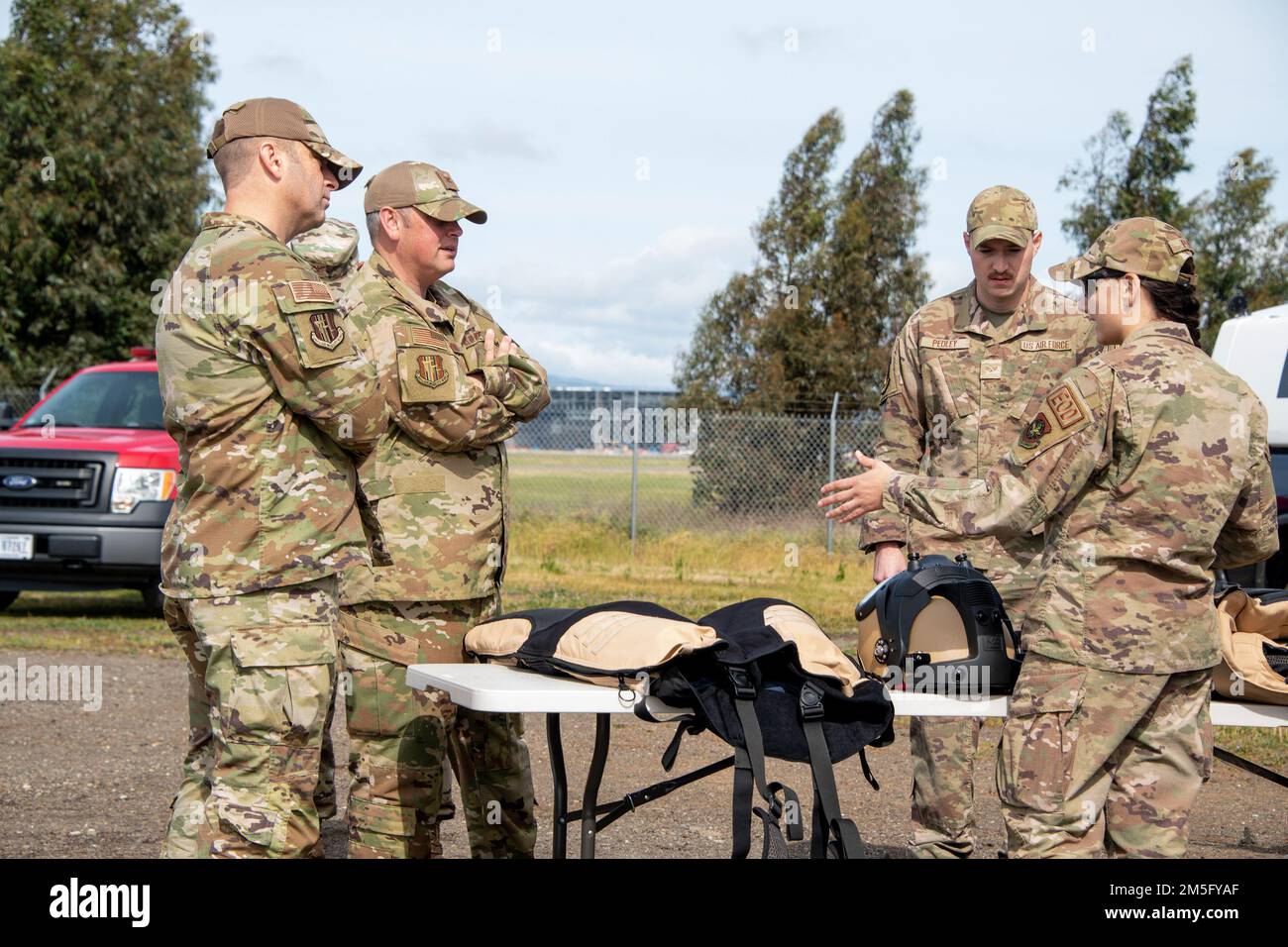 From left to right, U.S. Air Force Chief Master Sgt. Keith Scott, 60th Air Mobility Wing command chief, Col. Corey Simmons, 60th AMW commander, listen to Senior Airman Steven Pedley and SrA Serena Pedley, both 60th Civil Engineer Squadron Explosive Ordnance Disposal journeymen, during a visit to the EOD range at Travis Air Force Base, California, March 15, 2022. Trained to detect, disarm and dispose of explosive threats in extreme environments, EOD technicians serve as the Air Force’s bomb squad. Stock Photo