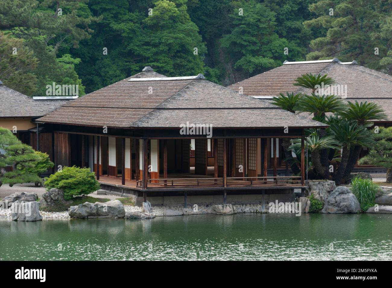 The lovely traditional Kikugetsutei Teahouse is fronted by a beautiful artificial pond and backed by the “borrowed scenery” of Mount Shiun, Takamatsu, Stock Photo