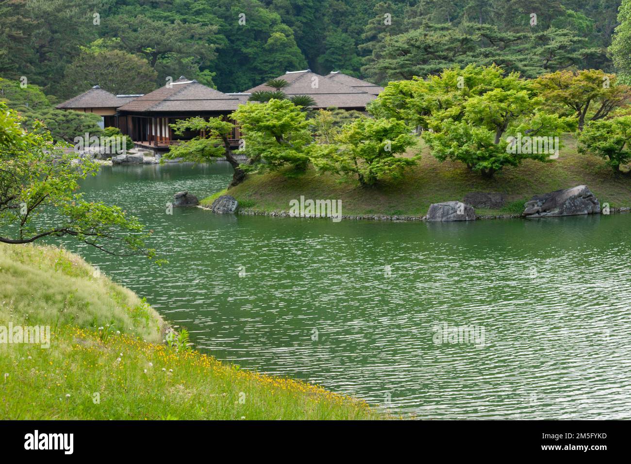 The lovely traditional Kikugetsutei Teahouse is fronted by a beautiful artificial pond and backed by the “borrowed scenery” of Mount Shiun, Takamatsu, Stock Photo