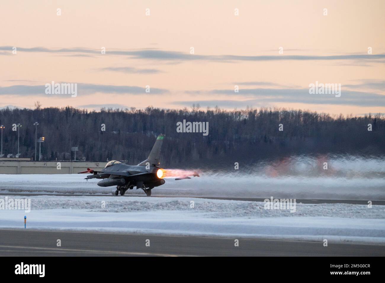A U.S. Air Force F-16 Fighting Falcon, Assigned to the Ohio National Guard’s 180th Fighter Wing, takes off for a training flight at Joint Base Elmendorf-Richardson, Alaska, during U.S. Northern Command Exercise ARCTIC EDGE 2022, March 15, 2022. AE22 is a biennial homeland defense exercise designed for U.S. and Canadian Armed Forces to demonstrate and exercise a joint capability to rapidly deploy and operate in the Arctic. Stock Photo