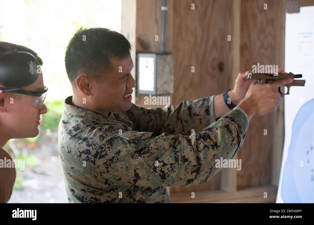 (220315-N-OI810-0478) KEY WEST, Florida (March 15, 2022) Staff Sgt. Socmaria Montana, right, from Las Angeles, California, assigned to Naval Air Station Key West (NASKW) Security, discusses site alignment and site picture with Steelworker 3rd Class Sean Sullivan, from Gulfport, Mississippi, assigned to Naval Mobile Construction Battalion (NMCB) 14, during weapons qualification for the M-18 service pistol at Boca Chica Field small arms range, Naval Air Station Key West (NASKW), March 15, 2022. Seabees assigned to NMCB-14 travelled to NASKW to complete a week-long course to increase combat readi Stock Photo