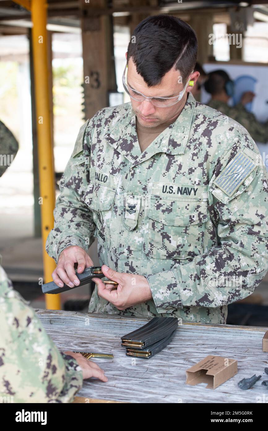 (220315-N-OI810-0611) KEY WEST, Florida (March 15, 2022) Construction Mechanic 2nd Class Matthew Mallow, from Margate, Florida, assigned to Amphibious Construction Battalion 2, loads 5.56mm rounds into magazines during weapons qualification for the M-4 service rifle at Boca Chica Field small arms range, Naval Air Station Key West (NASKW), March 15, 2022. Mallo joined Seabees assigned to Naval Mobile Construction Battalion (NMCB) 14 at NASKW to complete a week-long course to increase combat readiness and qualify in the M-18 pistol and M-4 rifle small arms platforms. NMCB-14 provides advance bas Stock Photo