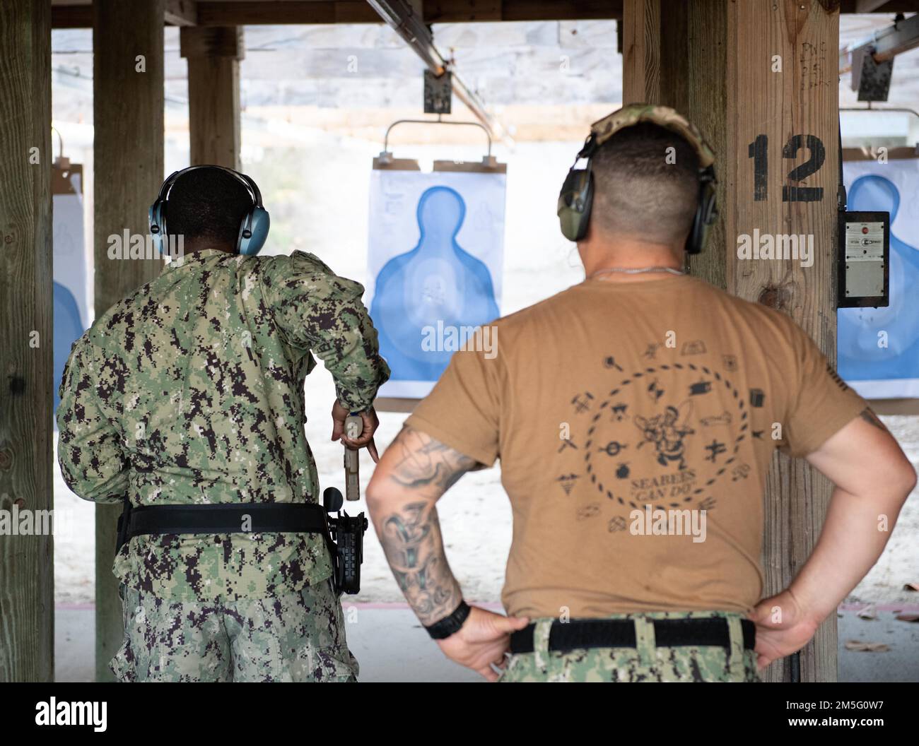 (220315-N-OI810-0354) KEY WEST, Florida (March 15, 2022) Seabees assigned to Naval Mobile Construction Battalion (NMCB) 14 conduct weapons qualification for the M-18 service pistol at Boca Chica Field small arms range, Naval Air Station Key West (NASKW), March 15, 2022. Seabees assigned to NMCB-14 travelled to NASKW to complete a week-long course to increase combat readiness and qualify members in the M-18 pistol and M-4 rifle small arms platforms. NMCB-14 provides advance base construction, battle damage repair, contingency engineering, humanitarian assistance and disaster recovery support to Stock Photo