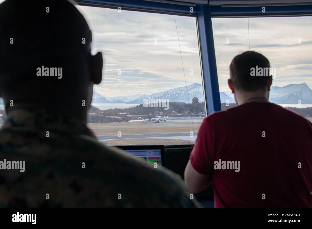 U.S. Marine Corps Sgt. Joshua Villegas (left) and Arnt-Einar Nilsen observe as a German Airbus A400M Atlas taxis on the runway during Exercise Cold Response 2022, Bodø, Norway, March 16, 2022. Villegas is an air traffic controller assigned to Marine Air Control Squadron 2, 2d Marine Aircraft Wing and Nilsen is a Norwegian civilian air traffic controller at Bodø Air Station. Exercise Cold Response '22 is a biennial Norwegian national readiness and defense exercise that takes place across Norway, with participation from each of its military services, as well as from 26 additional North Atlantic Stock Photo