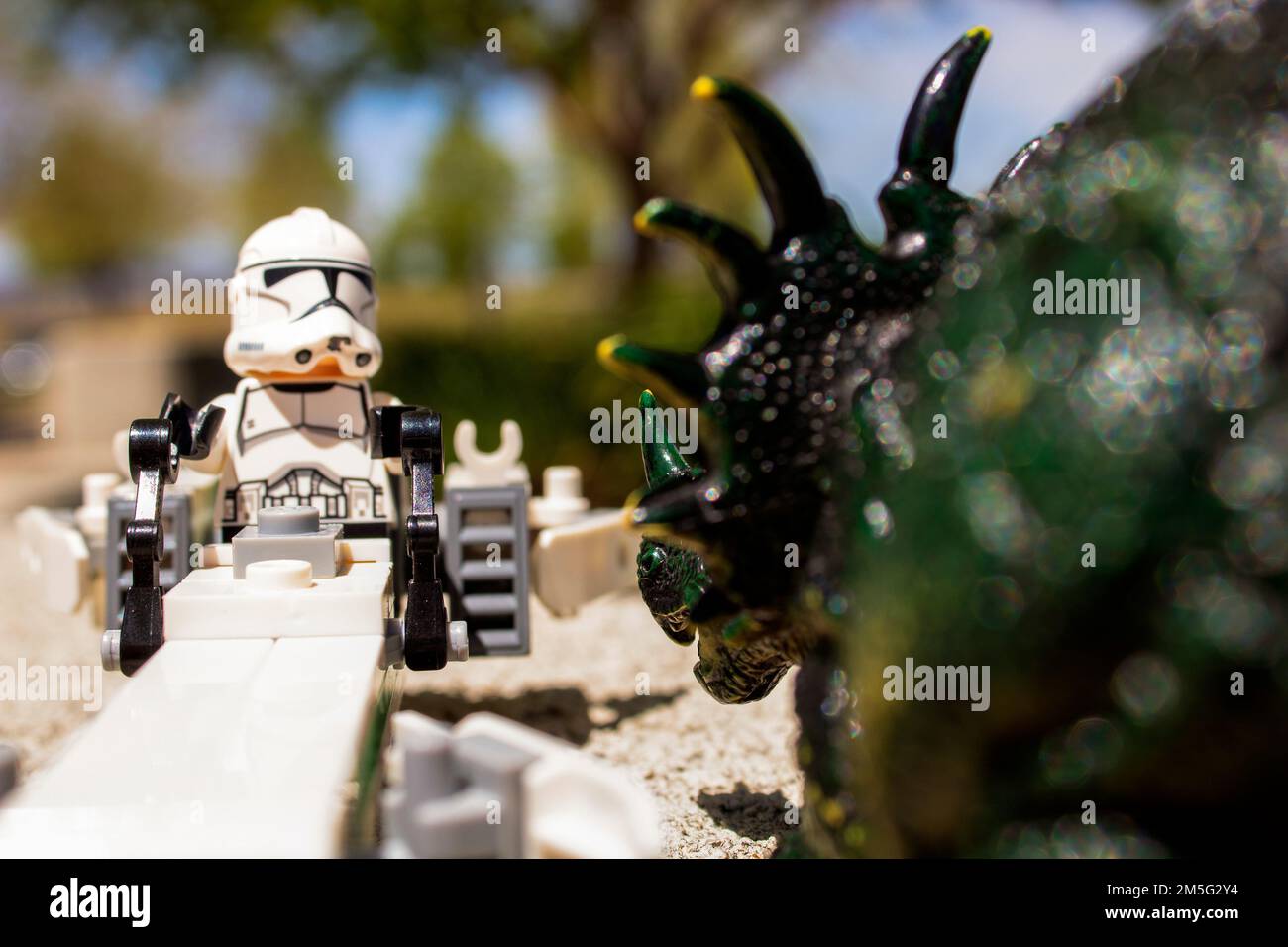 Toy Dinosaur Advancing On Lego Star Wars Storm Trooper Stock Photo