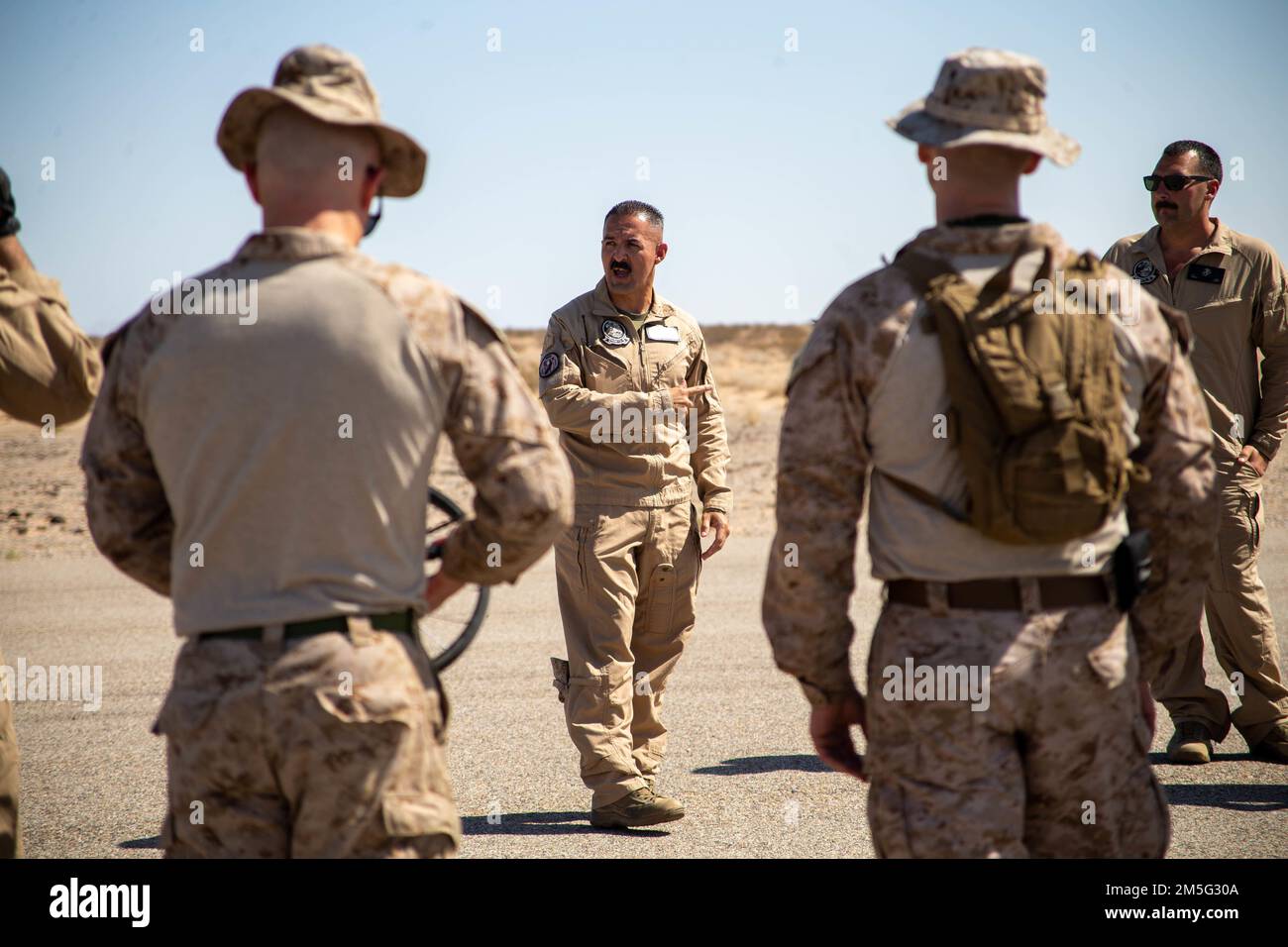 U.S. Marine Corps Master Sgt. Jesus Granados, a forward-arming refueling point coordinator, with Aviation Ground Support, Marine Aviation Weapons and Tactics Squadron One (MAWTS-1), instructs a forward arming and refueling point practical application, during Weapons and Tactics Instructor (WTI) course 2-22, at Auxiliary Airfield II, near Yuma, Arizona, March 16, 2022. WTI is a seven-week training event hosted by MAWTS-1, providing standardization advanced tactical training and certification of unit instructor qualifications to support Marine aviation training and readiness and assist in develo Stock Photo