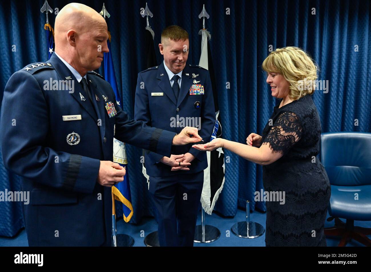 Chief of Space Operations Gen. John W. “Jay” Raymond hands rank insignia to the wife of Brig. Gen. Shawn Bratton during his promotion to major general at the Pentagon, Arlington, Va., March 16, 2022. Bratton is the commander of Space Training and Readiness Command. Stock Photo