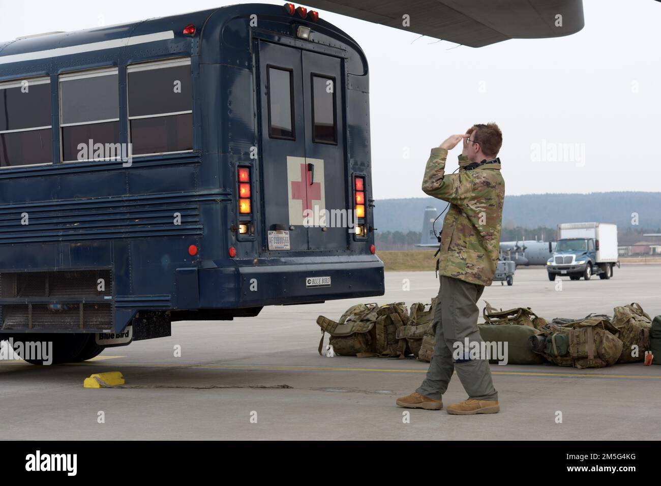 U.S. Air Force Senior Airman Zachary Glanz, 96th Airlift Squadron loadmaster, directs a medical bus at Ramstein Air Base, Germany, March 16, 2022. The 86th Aeromedical Evacuation Squadron and 86th Medical Group Critical Care Air Transport Teams flew with deployed members of the 96th AS to Poland to transport eight U.S. patients, who were then taken to Landstuhl Regional Medical Center shortly after landing. The 86th Airlift Wing supports several aeromedical evacuation capabilities including the 86th Medical Squadron’s Critical Care Air Transport Team, 86th Aeromedical Evacuation Squadron, and Stock Photo