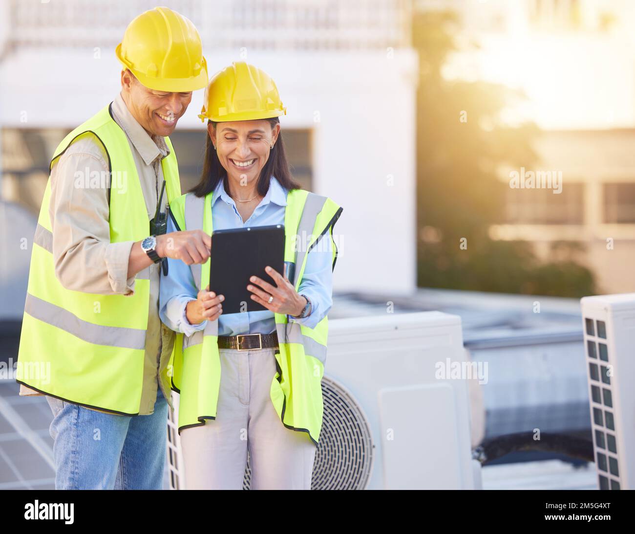 Engineer, man and woman with tablet for online research, schedule for building project and maintenance. Digital, people talking and construction Stock Photo