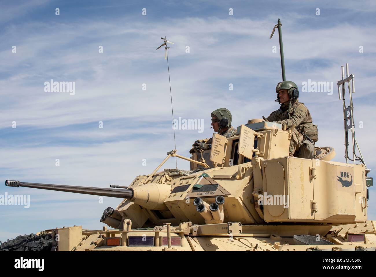 Soldiers of 2nd Armored Brigade Combat Team, 1st Armored Division observe their peers shoot targets from atop their Bradley Fighting Vehicle near Fort Bliss, Texas on March 16, 2022. 2nd BDE is performing gunnery tables for future training. Stock Photo