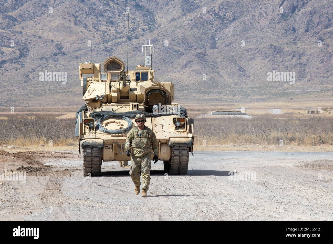 A Soldier from 2nd Armored Brigade Combat Team, 1st Armored Division ground guides a Bradley Fighting Vehicle off the range following their gunnery iteration near Fort Bliss, Texas, on March 16, 2022. 2nd BDE is participating in gunnery tables to prepare for upcoming training exercises. Stock Photo