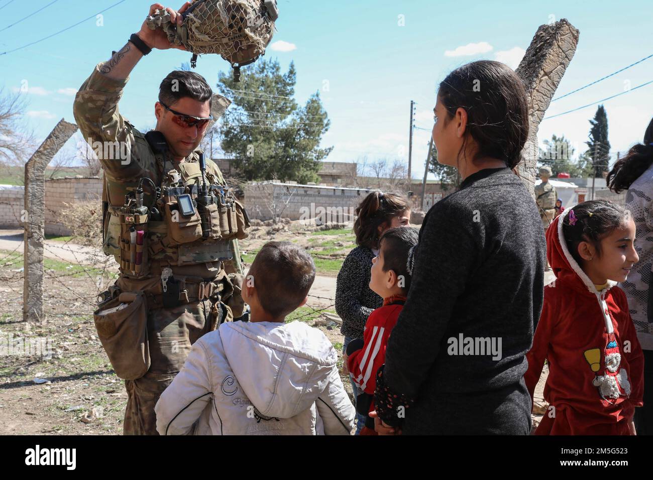 U.S. Soldiers assigned to Comanche Troop, 1st Brigade, 4th Infantry Division, engage with the local populace in Northeast Syria on March 16, 2022. Combined Joint Task Force - Operation Inherent Resolve continues to advise, assist, and enable partner forces in designated areas of Syria to set conditions for long-term security. Stock Photo