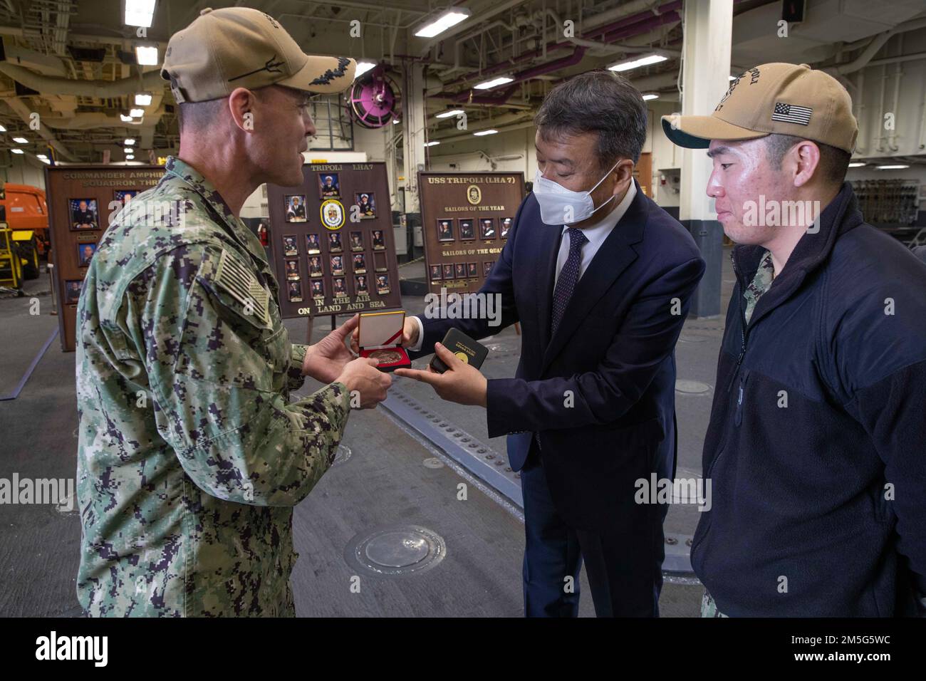 220316-N-CZ759-1088 SAN DIEGO (March 16, 2022) -- Director General  Guck-Cheol Bang, center, Director General of the Naval Ship Program  Department, Republic of Korea Defense Acquisition Program Administration,  presents a gift to amphibious