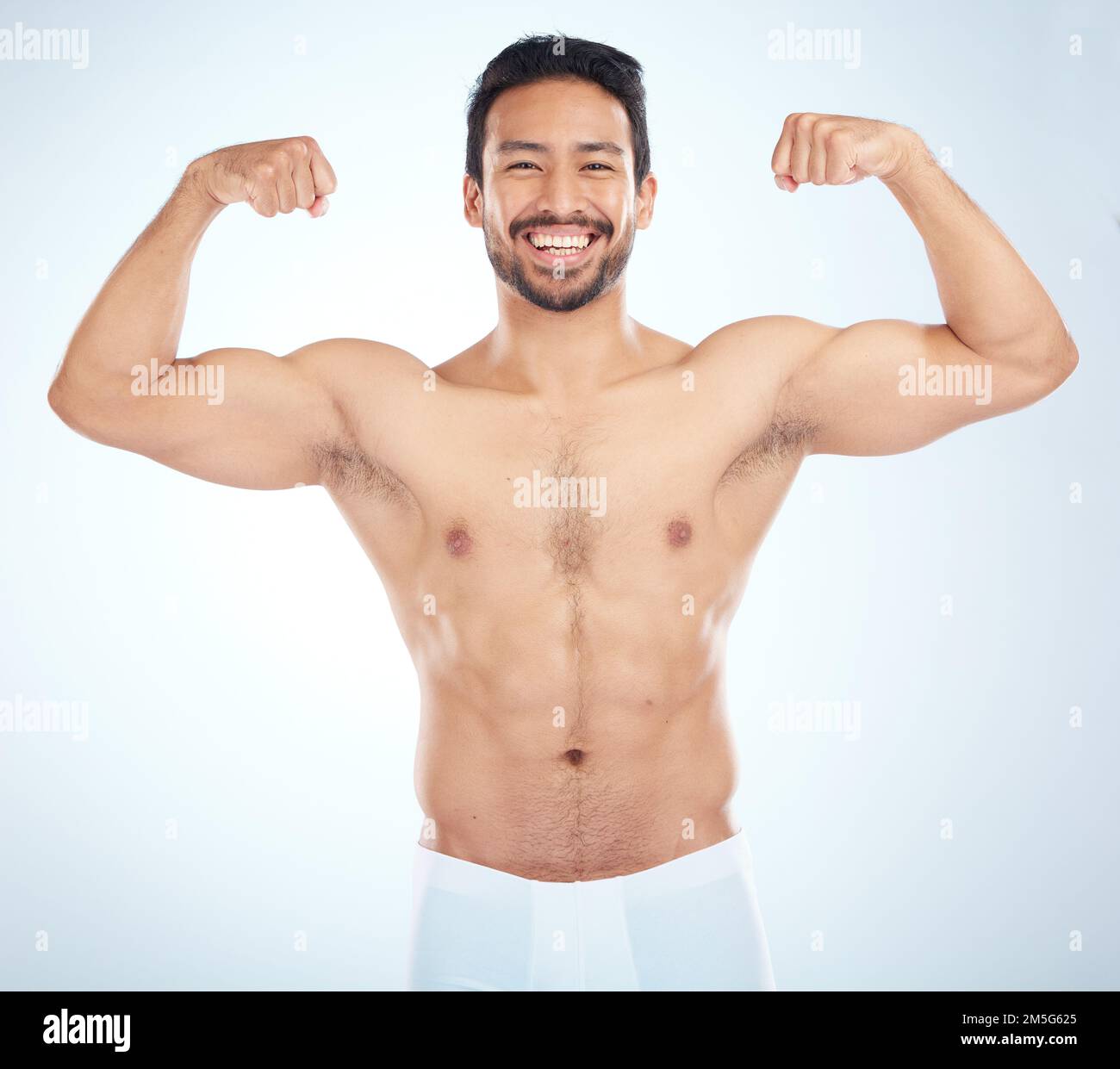 Fitness, biceps and portrait of a man flexing in a studio after an arm muscle training workout. Sports, health and strong Asian male bodybuilder after Stock Photo