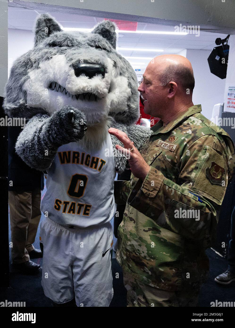 Wright State mascot Rowdy Raider and Col. Patrick Miller, 88th Air Base Wing and Wright-Patterson Air Force Base commander, greet each other March 16, 2022, prior to the opening ceremony of the NCAA men’s basketball tournament game between Wright State and Bryant. Wright State, a hometown team whose campus borders Wright-Patterson, went on to win the game and advance to the next round of tournament play. Stock Photo