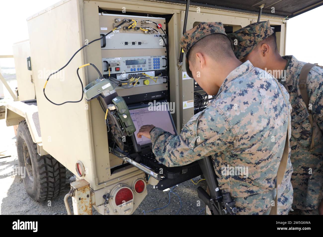 U.S. Marine Corps Cpl. Johnson Nghiem, left, a network administrator and Cpl. Fabian Aguilar, a data systems administrator with 9th Communication Battalion, I Marine Expeditionary Force Information Group, troubleshoots satellite communication during a combat readiness evaluation at Marine Corps Base Camp Pendleton, California, March 16, 2022. The Marines with 9th Communication Battalion established internet service and enhanced the capability of operating, defending, and preserving network operations in the information environment. Stock Photo