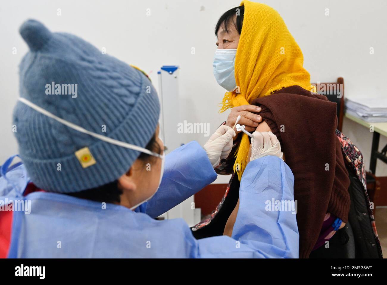 WEIFANG, CHINA - DECEMBER 29, 2022 - A medical worker inoculates a citizen with a second dose of booster vaccine at a centralized COVID-19 vaccination Stock Photo