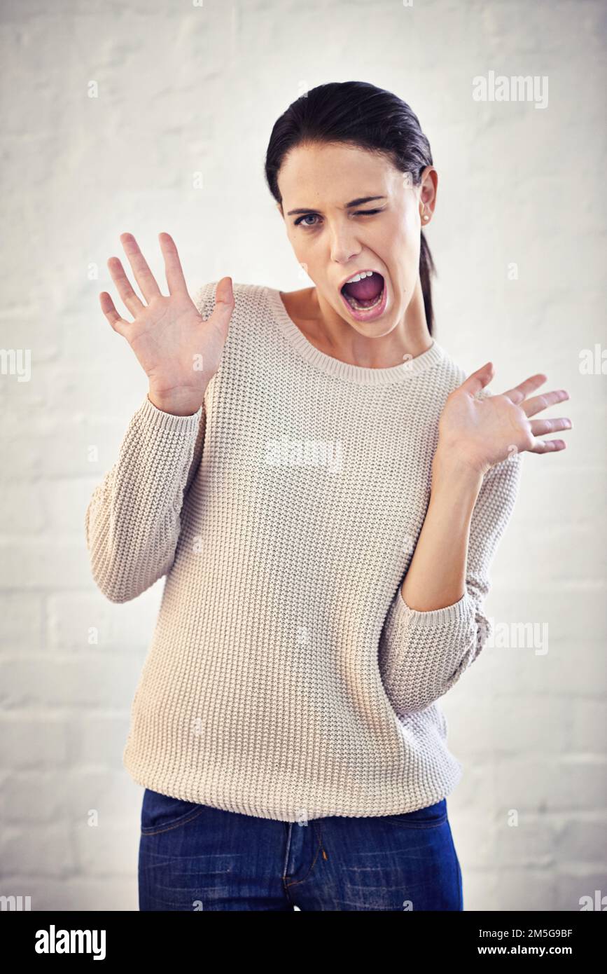 Jazz hands. a young woman with her hands in the air looking surprised. Stock Photo