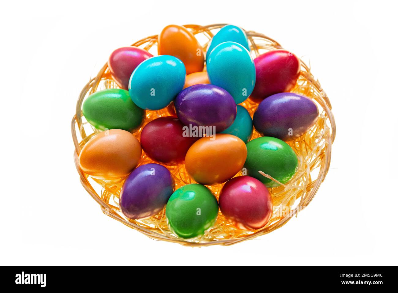 Easter multicolored painted eggs in a wicker bowl on a white background.Easter food. Spring religious holiday symbol. Easter tradition. Christian and Stock Photo