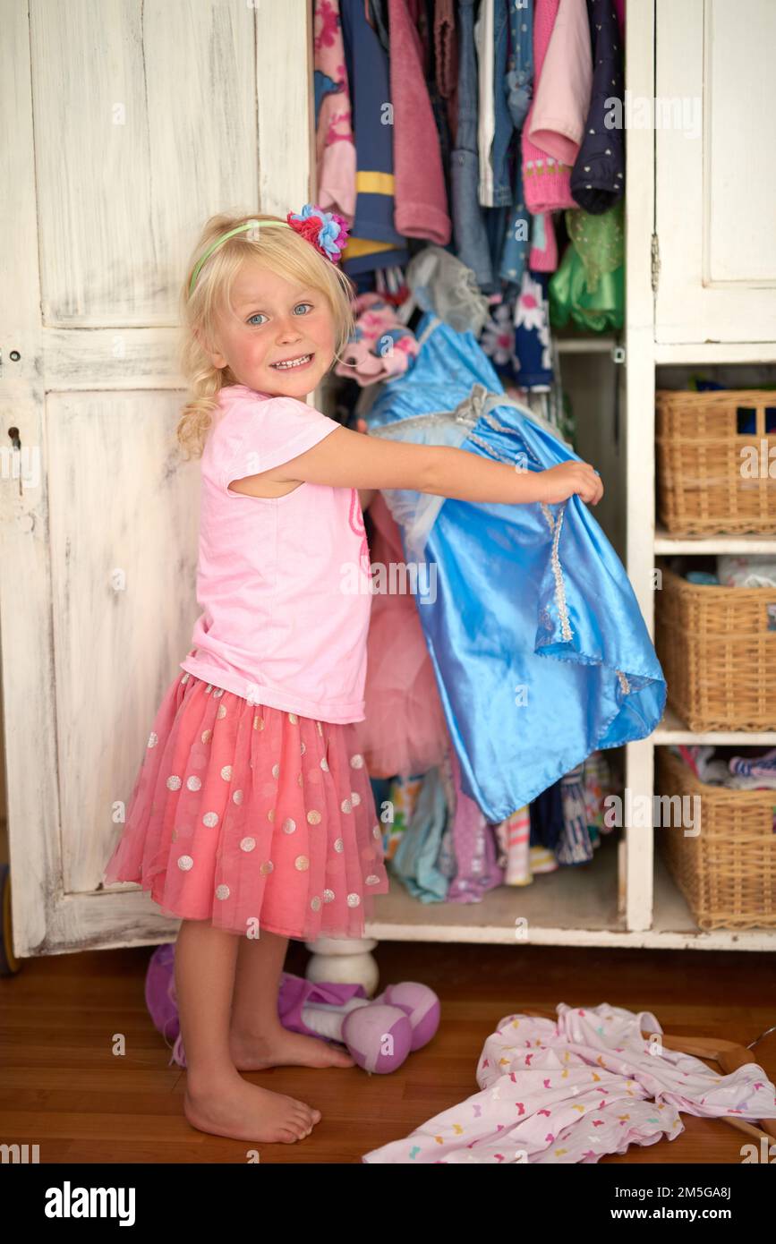 This is my princess dress. Portrait of a young girl looking through her wardrobe. Stock Photo