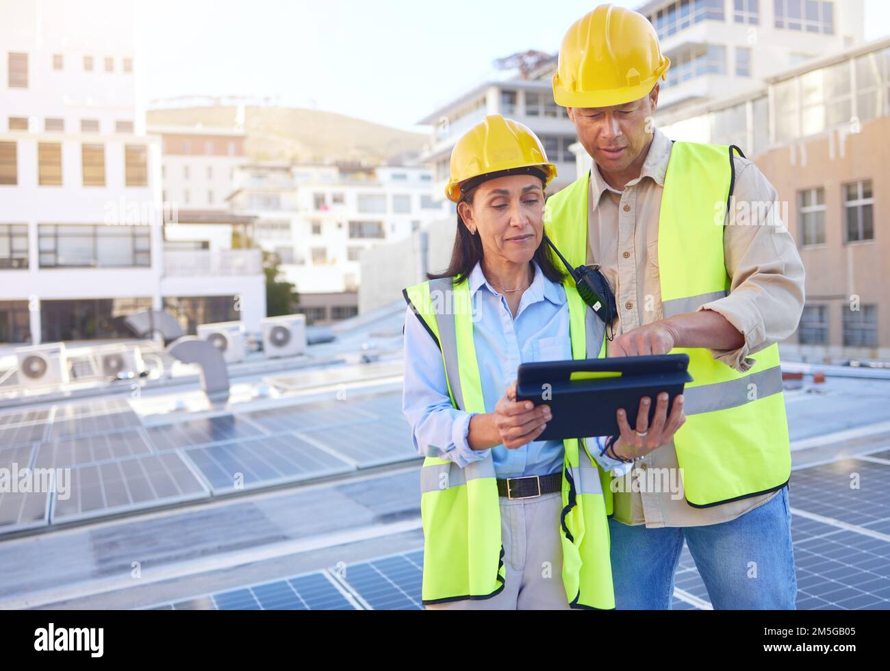Engineer, man and woman with tablet for online research, schedule for building project and maintenance. Digital, people talking and construction Stock Photo