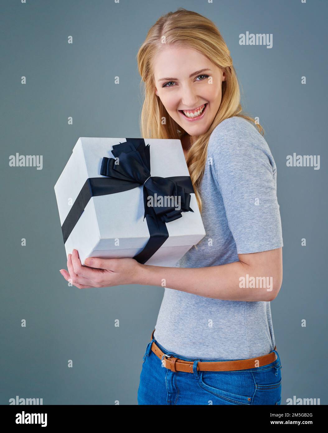 For me You shouldnt have. Cropped studio shot of a happy young woman receiving a present. Stock Photo