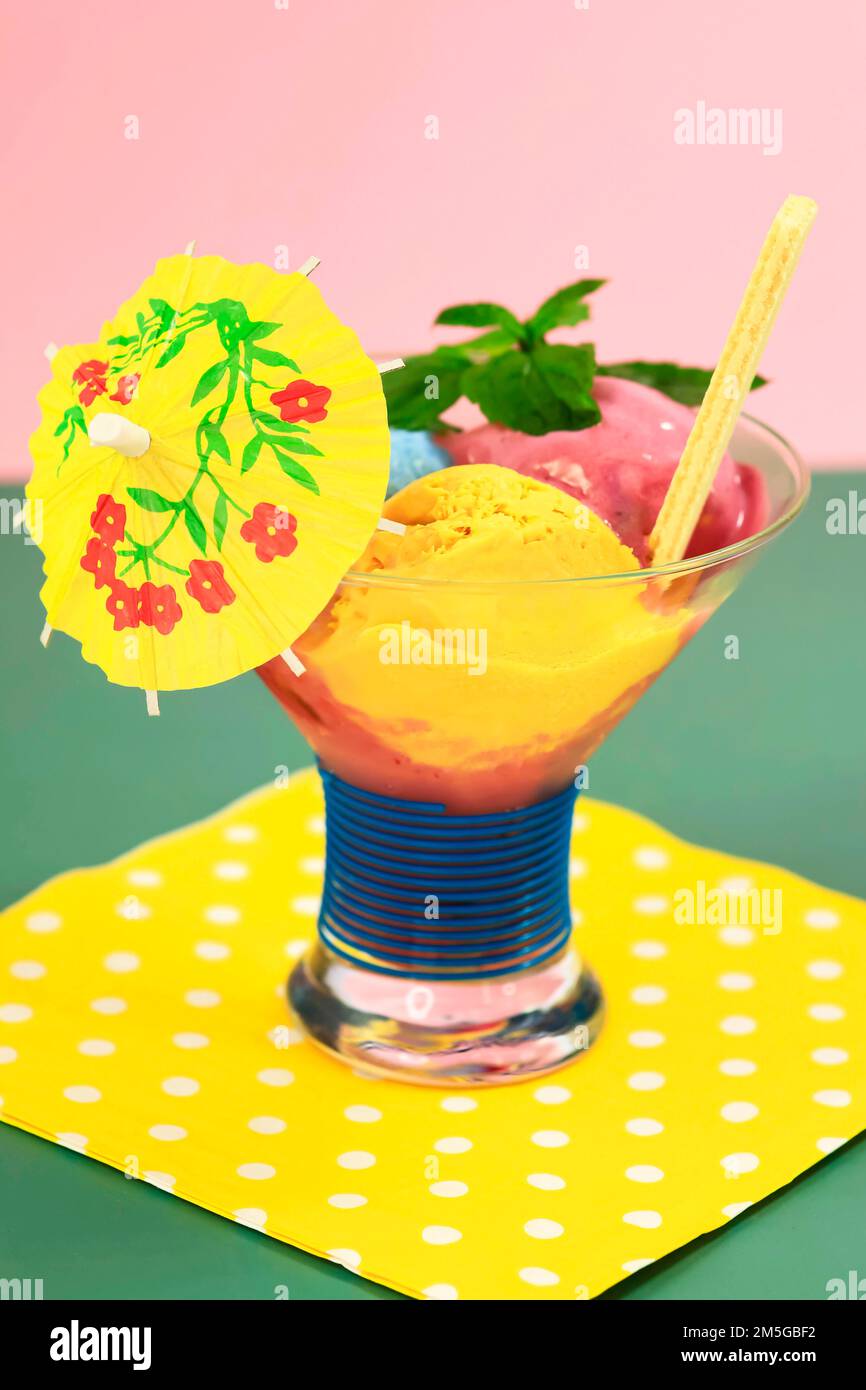 Sundae with homemade ice cream, yellow umbrella, ice cream cone and