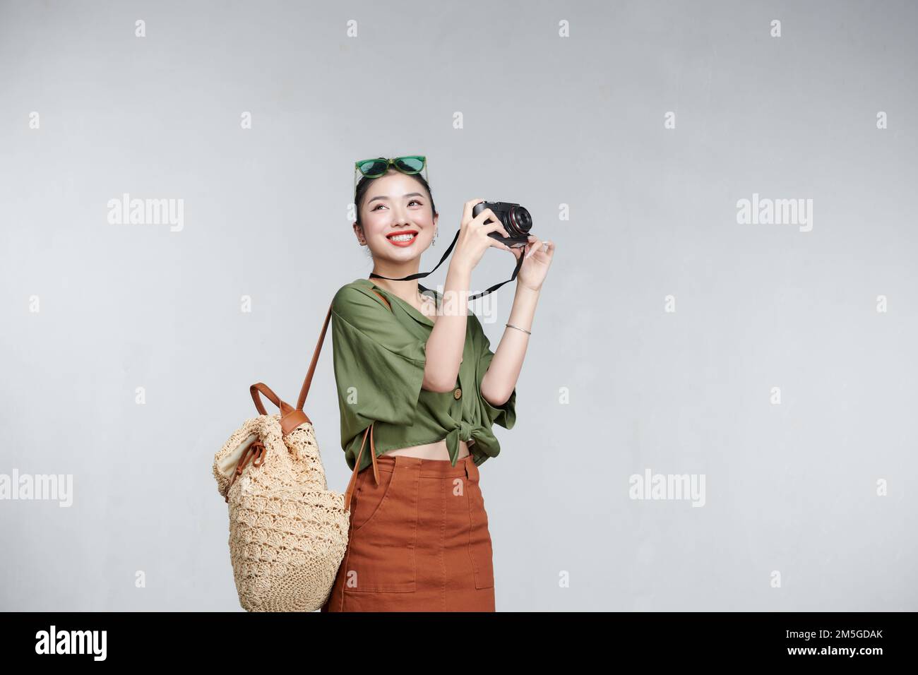 Smiling woman traveler holding camera in holiday Stock Photo