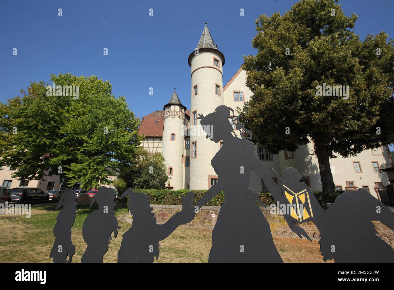 Figures from the fairy tale Snow White and the Seven Dwarfs in front of the late Gothic castle built approx. 1340 in Lohr am Main, Lower Franconia Stock Photo
