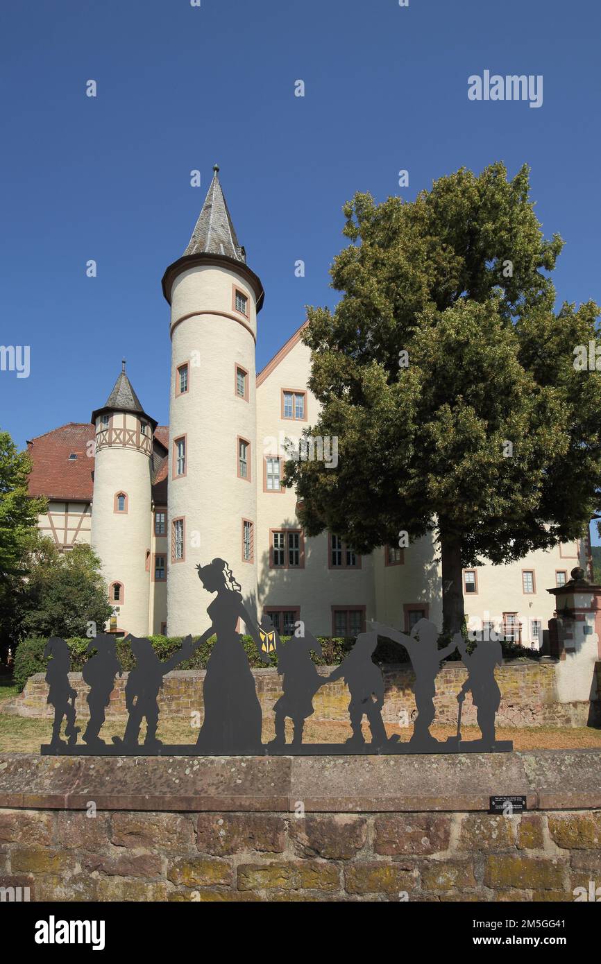 Figures from the fairy tale Snow White and the Seven Dwarfs in front of the late Gothic castle built approx. 1340 in Lohr am Main, Lower Franconia Stock Photo