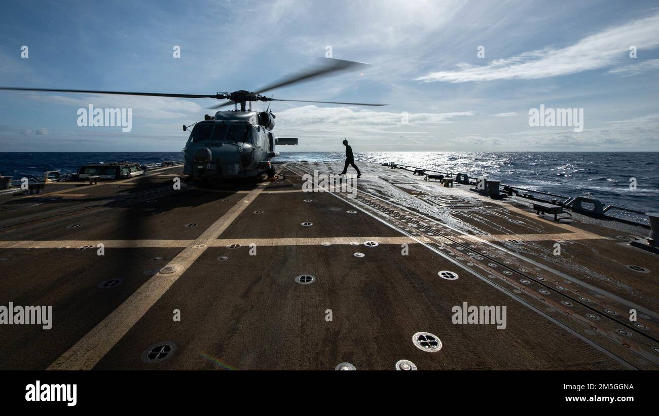PHILIPPINE SEA (March 17, 2022) Aviation Electrician’s Mate 2nd Class Isaac Firlit, from Swanswen, Mass., crosses the flight deck to complete a final inspection before the launch of an MH-60R Sea Hawk helicopter, assigned to the “Raptors” of Helicopter Maritime Strike Squadron (HSM 71), from the flight deck of Arleigh Burke-class guided-missile destroyer USS Spruance (DDG 111). Abraham Lincoln Strike Group is on a scheduled deployment in the U.S. 7th Fleet area of operations to enhance interoperability through alliances and partnerships while serving as a ready-response force in support of a f Stock Photo