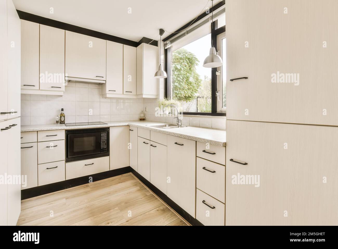 a kitchen with white cupboards and black trim on the cabinets in