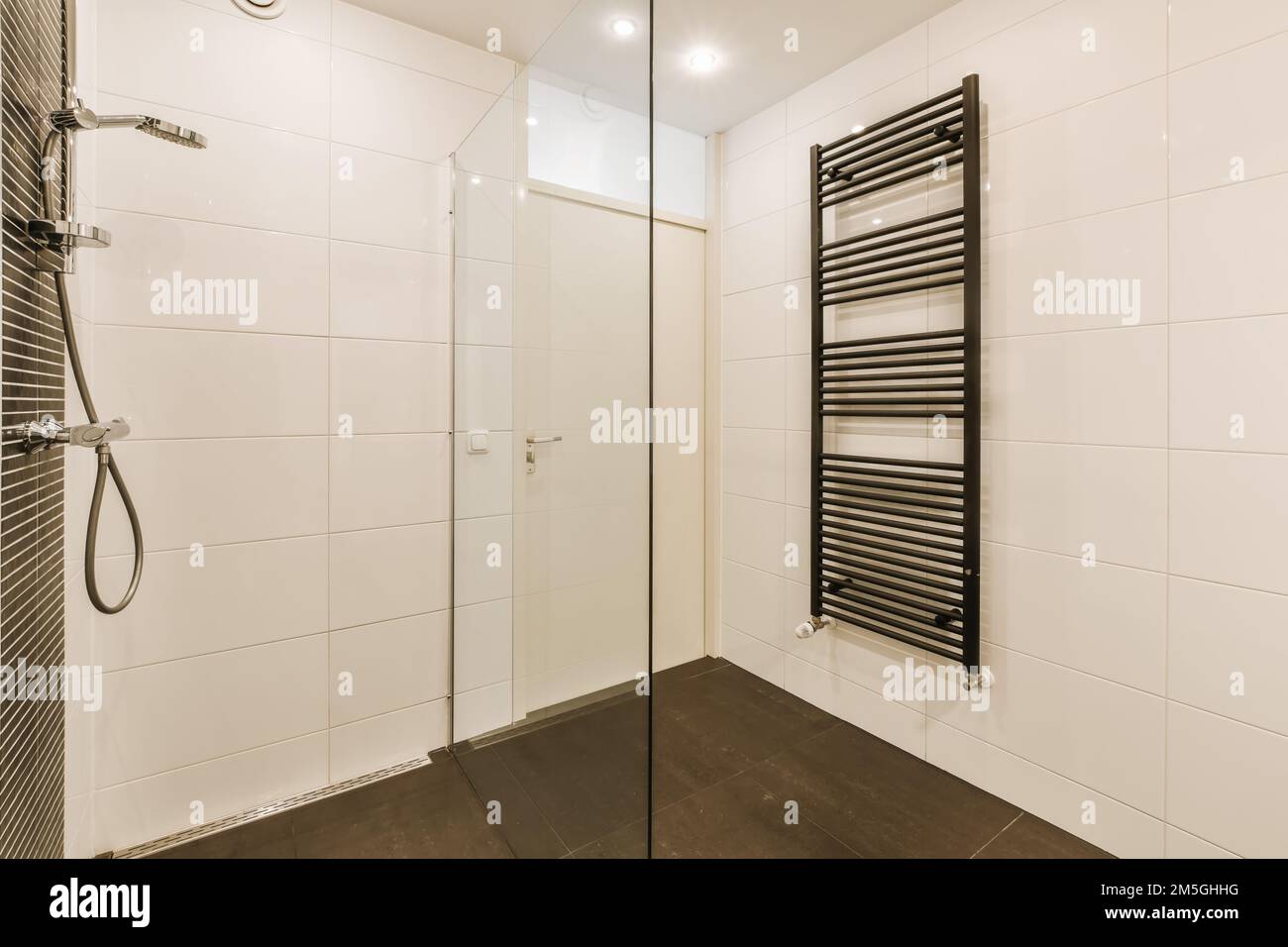 a modern bathroom with black and white tiles on the walls, along with a ...