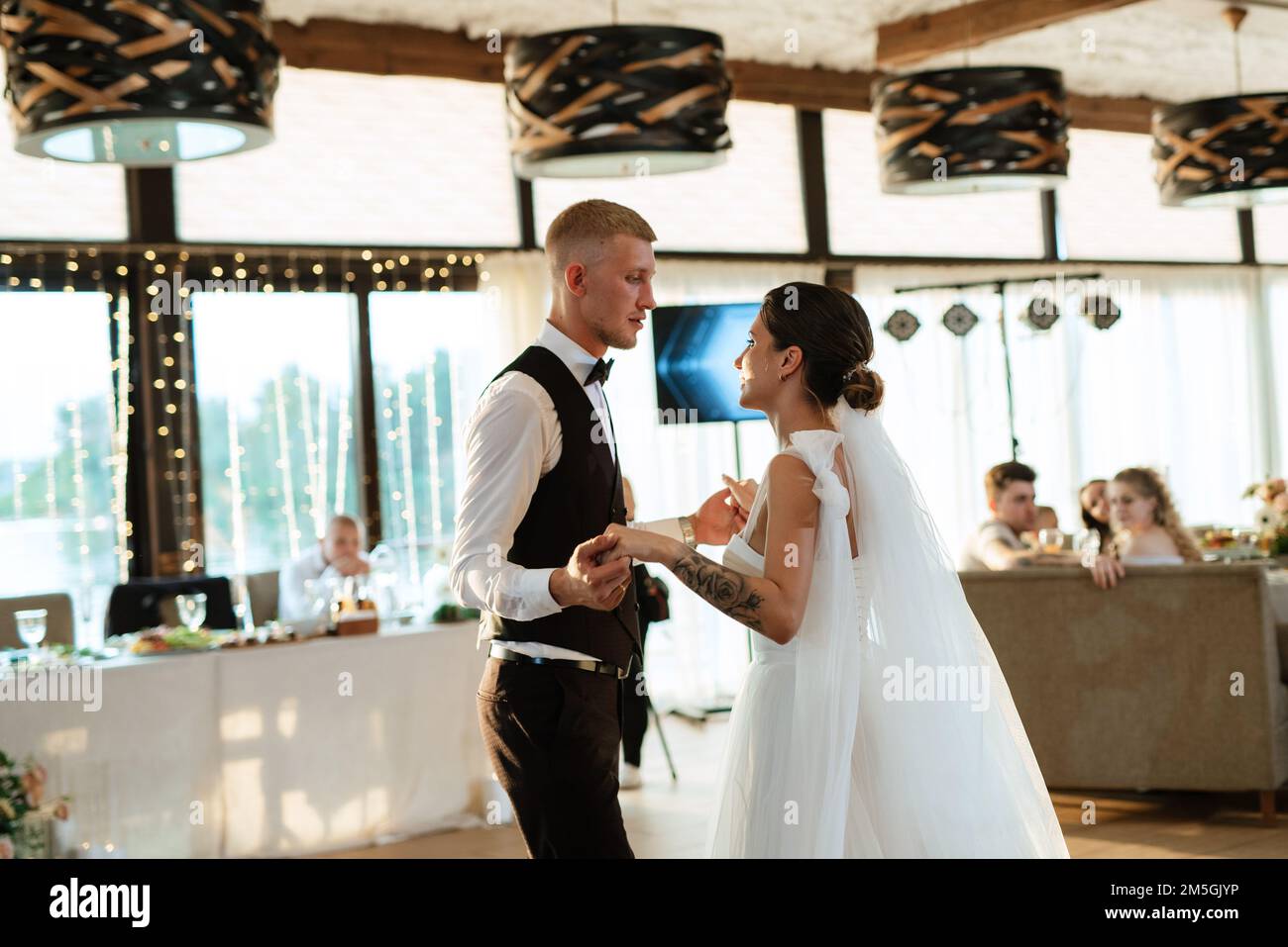 the first wedding dance of the bride and groom inside the restaurant