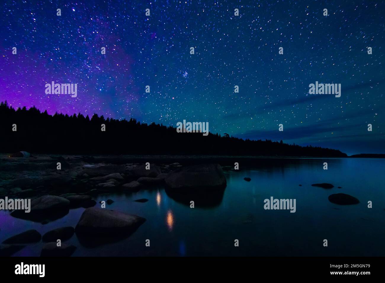 night landscape with a starry sky and milky way over the water of a ...