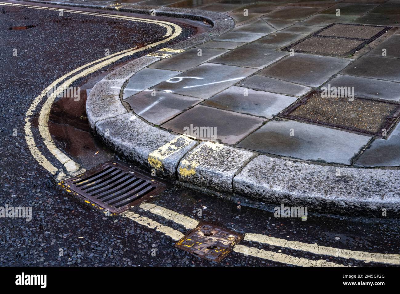 Double yellow no parking lines on a cirved kerb in London Stock Photo