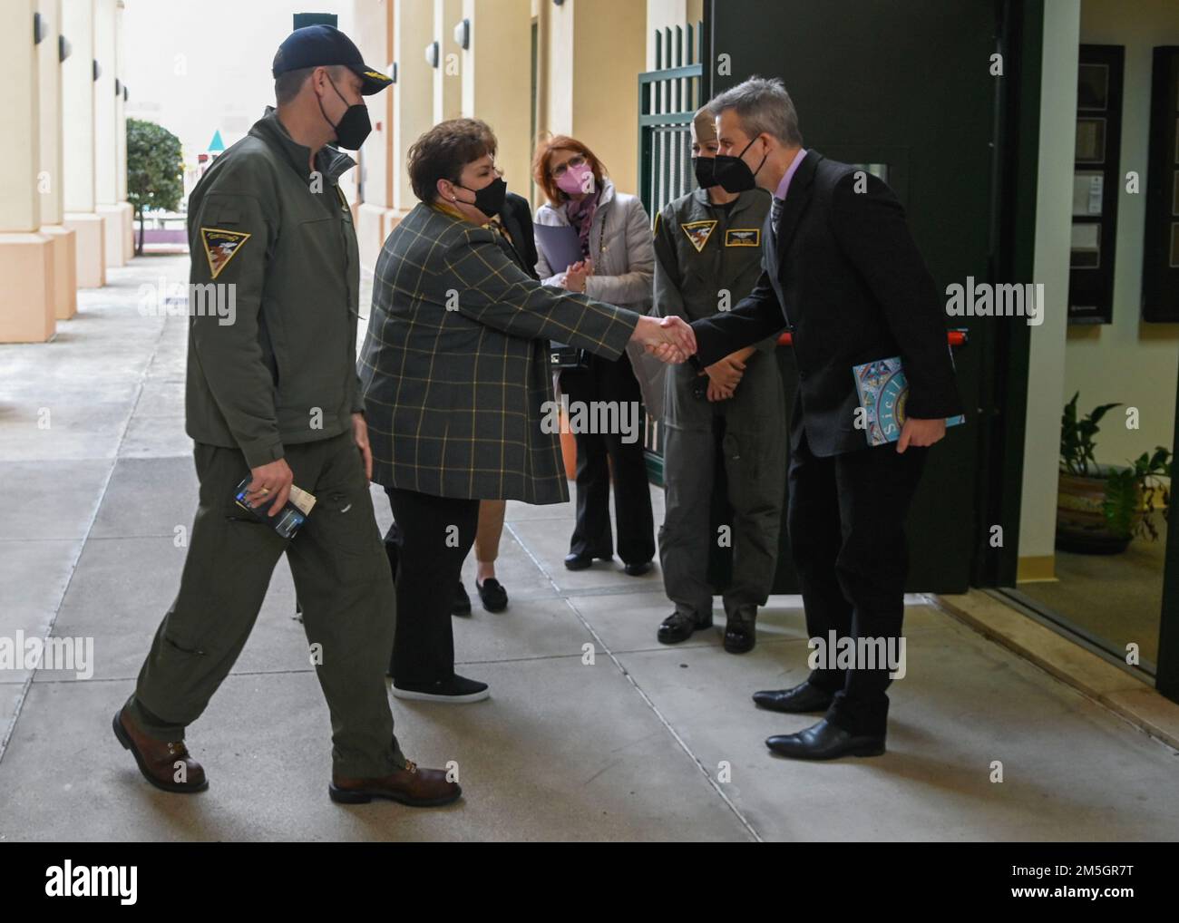 220317-N-GK686-2132 NAVAL AIR STATION SIGONELLA, Italy (March 17, 2022) – Marc Villarreal, Sigonella Middle/High School principal, left, greets Mrs. Betty Del Toro, wife of the secretary of the Navy, before a look at the school as part of a tour of Naval Air Station Sigonella, March 17, 2022. NAS Sigonella’s strategic location enables U.S., allied, and partner nation forces to deploy and respond as required, ensuring security and stability in Europe, Africa, and Central Command. Stock Photo