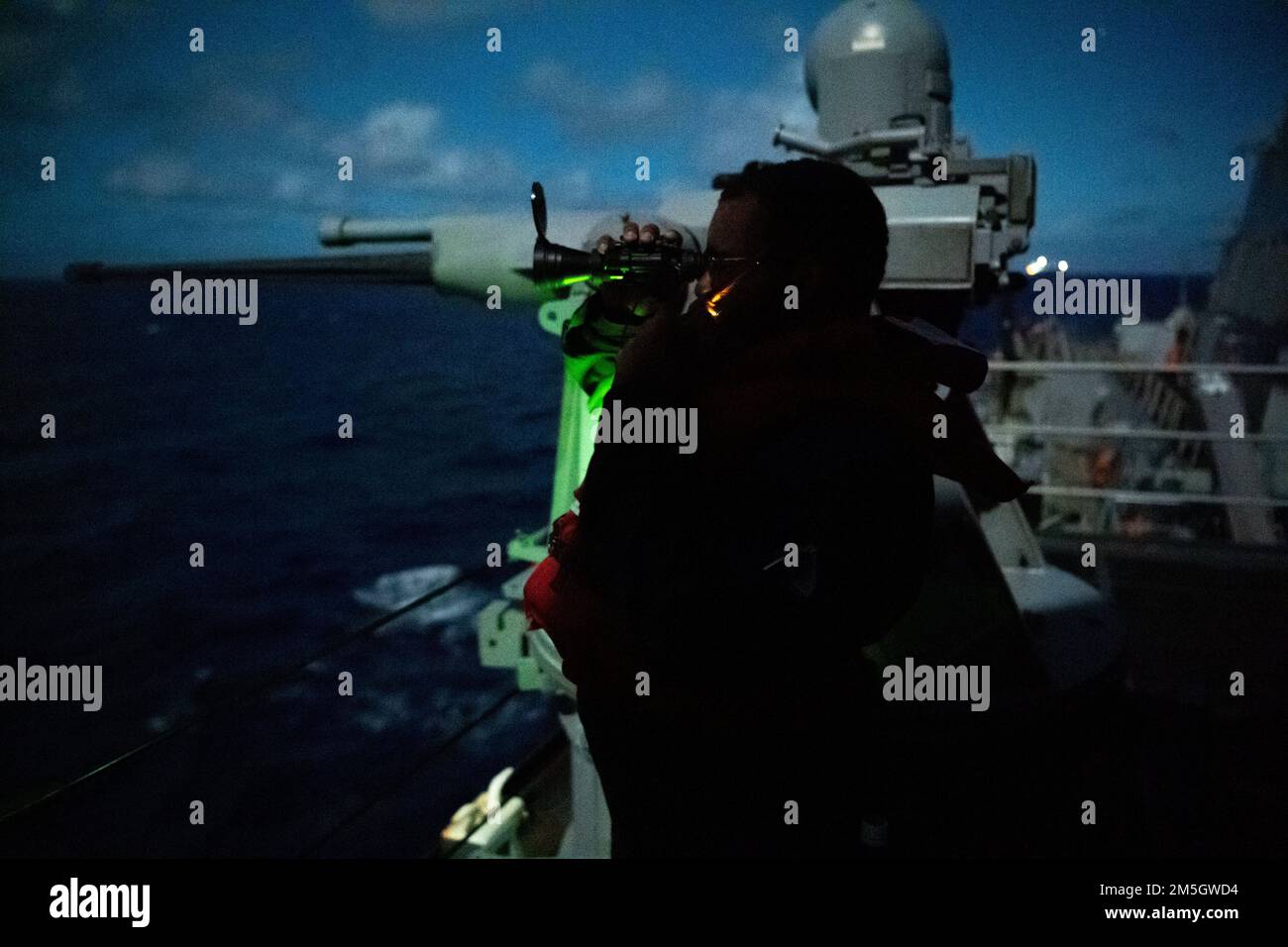 PHILIPPINE SEA (March 17, 2022) Gunner’s Mate 2nd Class Taquan Taylor, from Mobile, Alabama, mans the Mark 38 – 25 mm machine gun aboard the Arleigh Burke-class guided-missile destroyer USS Dewey (DDG 105) while conducting routine operations underway in the U.S. 7th Fleet area of responsibility. Dewey is assigned to Destroyer Squadron (DESRON) 15 and is underway supporting a free and open Indo-Pacific. CTF 71/DESRON 15 is the Navy’s largest forward-deployed DESRON and the U.S. 7th Fleet’s principal surface force. Stock Photo