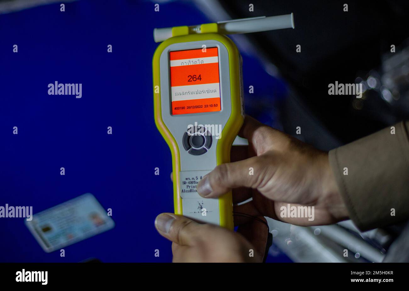 A Thai police officer shows the breathalyzer with a higher than normal for alcohol tests at Check point in Chiang Mai. The Center for Prevention and Reduction of Road Accidents has been established during the New Year's Festival 2023, the 7-day intensive control period from 29 December 2022 to 4 January 2023. More than 50,000 police officers are to set up checkpoints to facilitate traffic laws and take care of the safety of people. They will work throughout the festival without holidays, focusing on 4 charges according to government policy: driving while intoxicated, driving too fast, and not Stock Photo