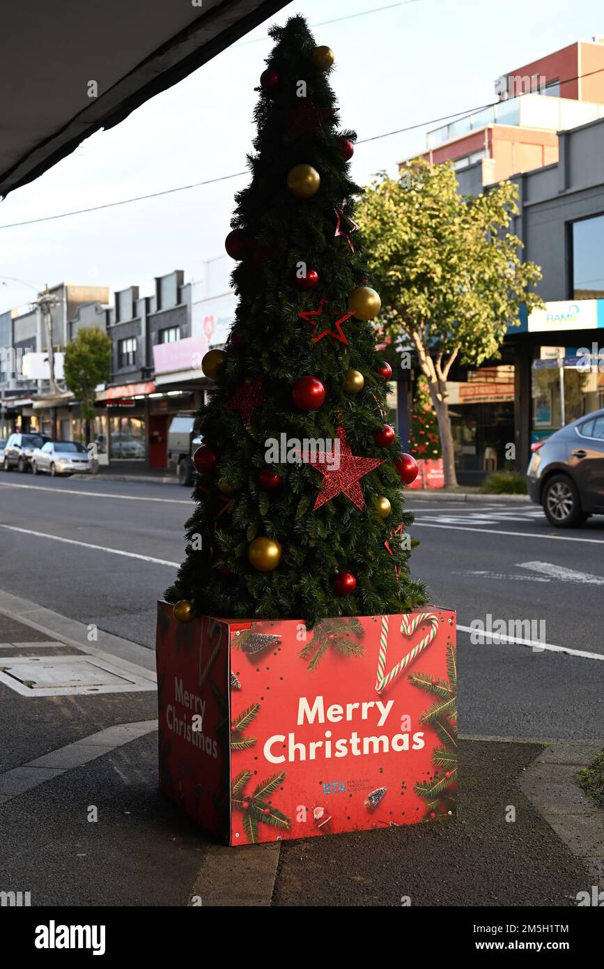 Christmas tree, with a Merry Christmas message from the Bentleigh Traders Association, located on the footpath at the Centre Rd shopping strip Stock Photo